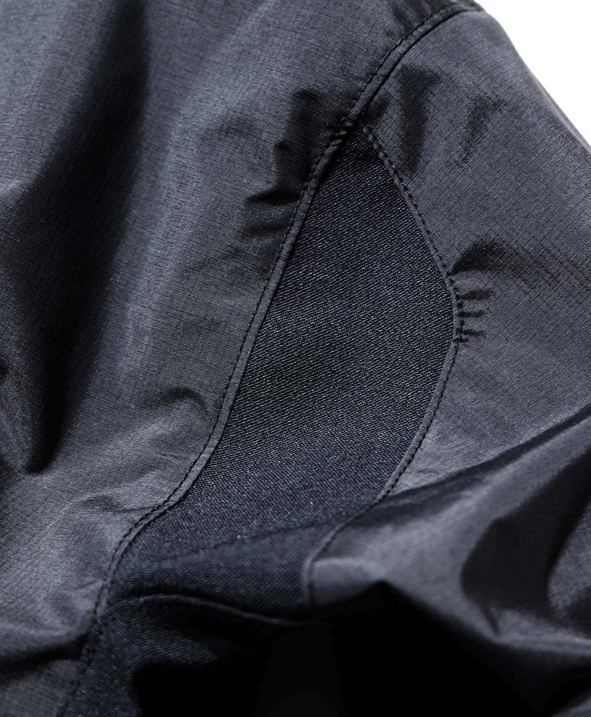 杢調のリップストップナイロン素材とストレッチナイロンを切り替え、味わいのあるシックな質感と運動性に拘った一着。